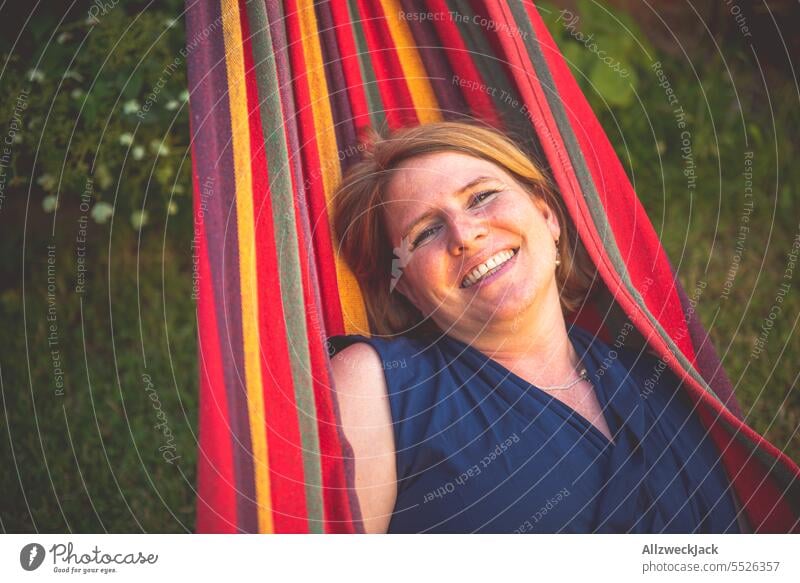 Portrait of young blonde woman smiling lying in hammock Woman Young woman Sympathy Congenial pretty pretty woman Attractive attractiveness smilingly Smiling