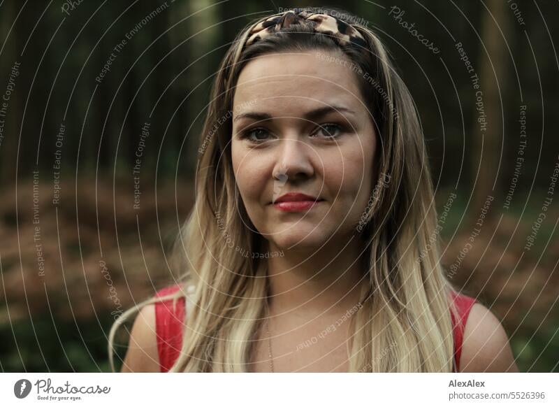 Portrait of beautiful blonde long haired woman standing in light forest looking at camera Woman pretty Blonde Long-haired Blonde hair long hairs red dress Red