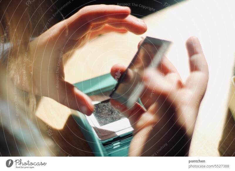 framed slides in children hands. A child looks at framed slides in a box. Analog photography Slide analogue photography children's hands look at vintage