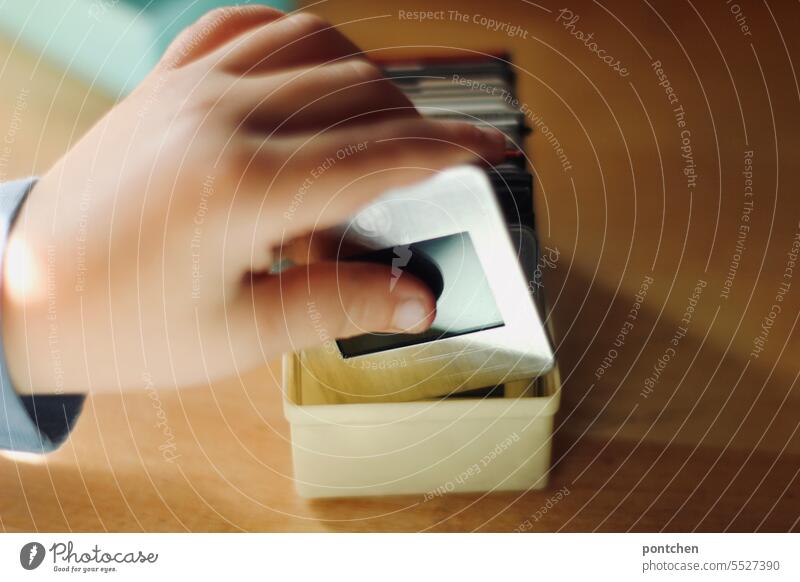 framed slides in children hands. A child looks at framed slides in a box. Analog photography Slide analogue photography children's hands look at vintage