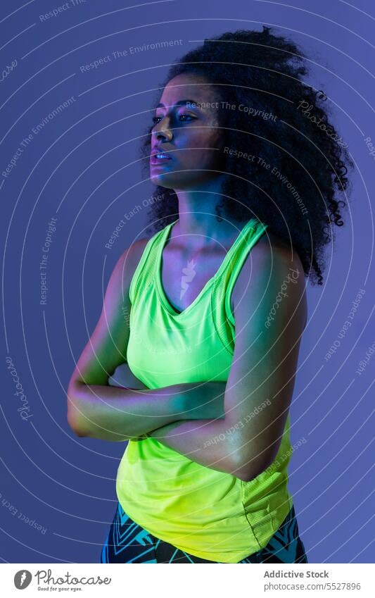 Black woman in headphones standing portrait hand on waist studio shot sport fitness female sportswoman meloman sound activewear wellness sportswear young