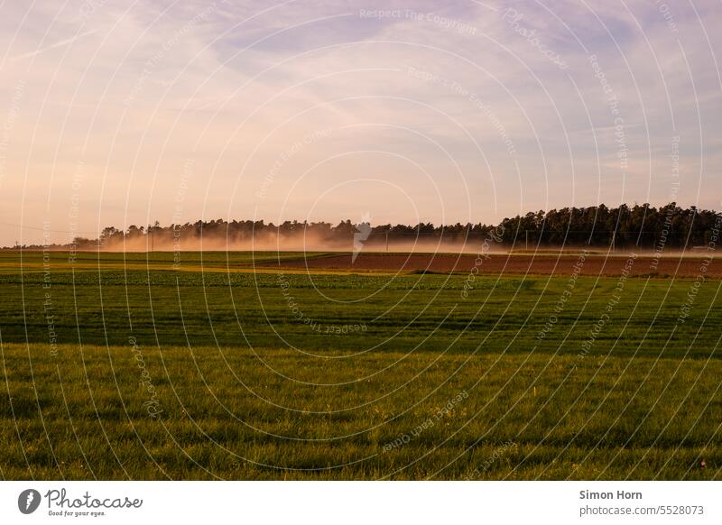 Fog lies over agricultural land wafts of mist evening light fields Agriculture day's work Closing time agricultural area Landscape Working in the fields Field