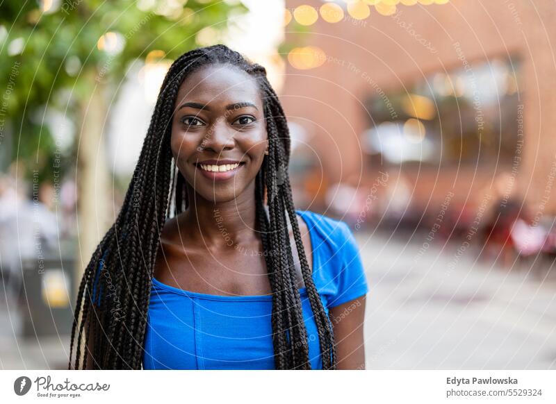 Portrait of a beautiful young woman smiling in the city adult attractive black confidence confident cool female girl hairstyle leisure lifestyle natural