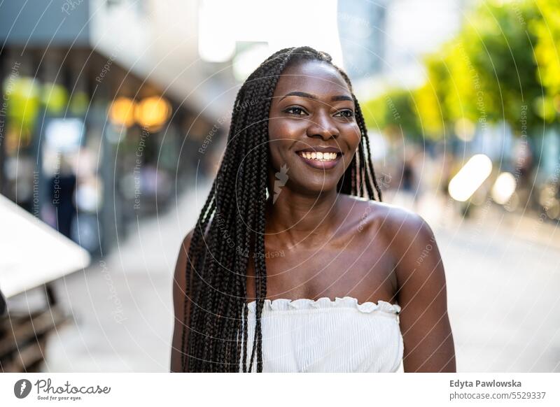 Portrait of a beautiful young woman smiling in the city adult attractive black confidence confident cool female girl hairstyle leisure lifestyle natural