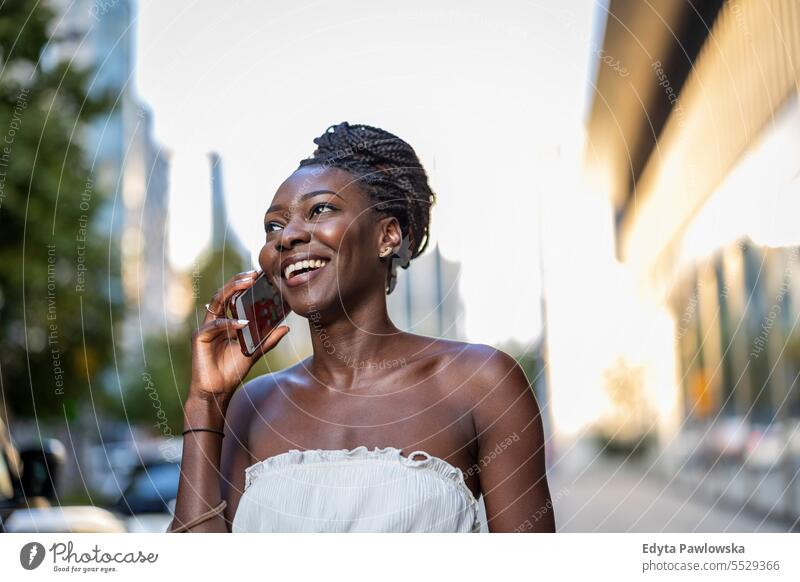 Portrait of an young woman using mobile phone in the city adult attractive beautiful black confidence confident cool female girl hairstyle leisure lifestyle