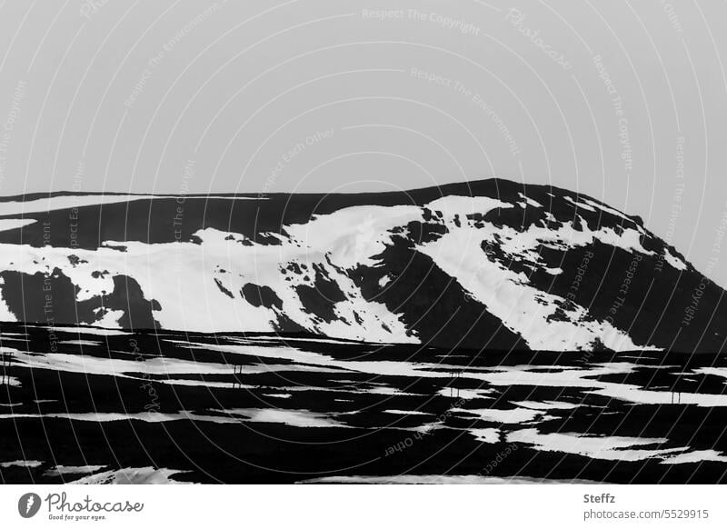 Ski resort on a mountain side in Iceland Ski run skiing season End of the season Icelandic Rock mound Hill Mountain side Hill side Ski lift snow stains