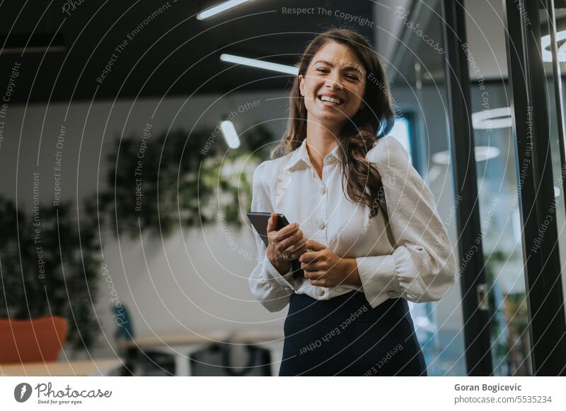 Young woman with digital tablet standing in the modern office young businesswoman female attractive technology portrait wireless occupation confident