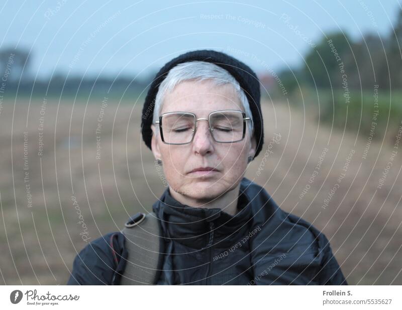 Wide land | dreamlike portrait Closed eyes Landscape Jacket Horizon Woman Autumn relaxed Dream black cap black jacket Black Eyeglasses