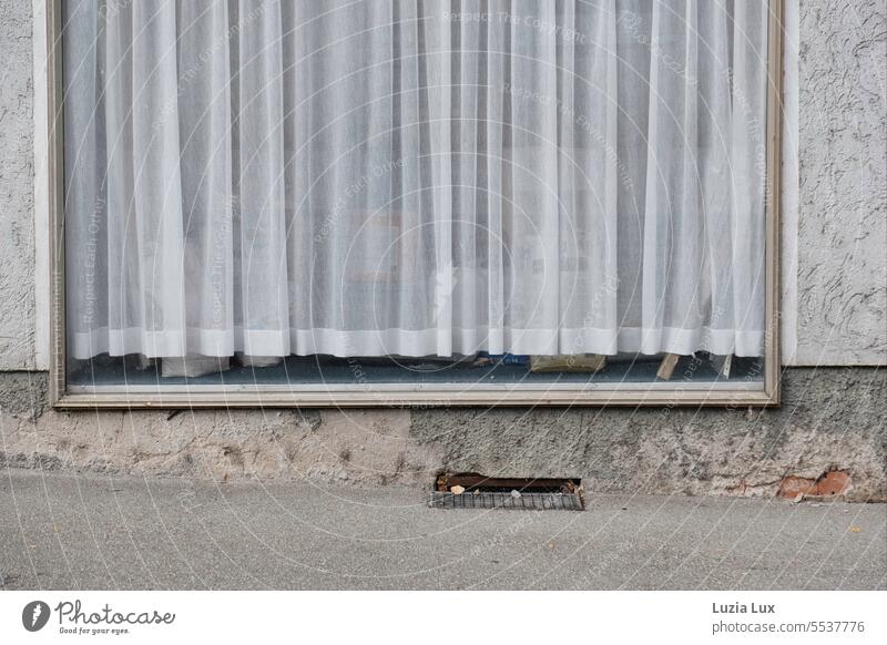 In the old shop window to the street a delicate curtain, behind it piles renovation materials Gray Glass forsake sb./sth. business Shop window Retail sector