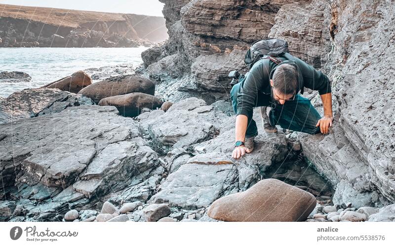 Man exploring rocky environment hike traveler explore explorer looking for searching Curiosity curious nature Rock rocks Stone stones person Human being