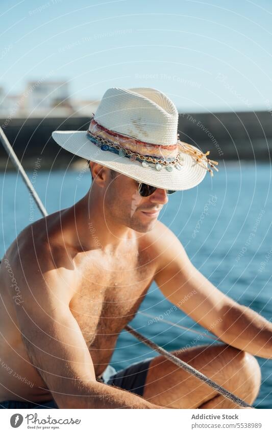 Handsome man on sailboat in the ocean yacht sensual summer vacation confident sensuality cruise body dreamer stylish vessel model outdoors male natural fit