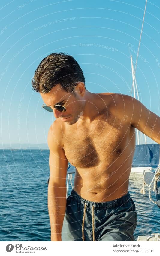 Handsome man on sailboat in the ocean yacht sensual summer vacation confident sensuality cruise body dreamer stylish vessel model outdoors male natural fit