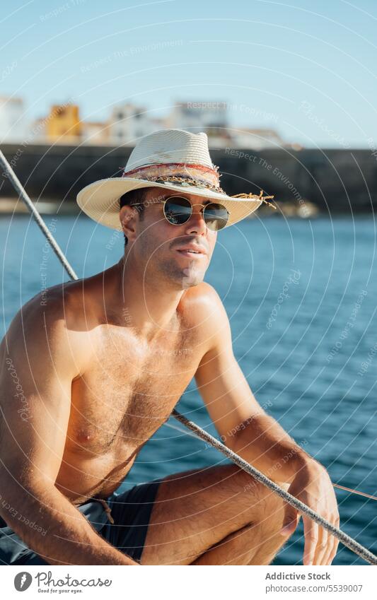 Handsome man on sailboat in the ocean yacht sensual summer vacation confident sensuality cruise body dreamer stylish vessel model outdoors male natural fit