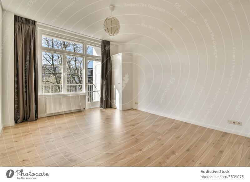 Living room with large window with white walls living room empty light fixture hanging radiator house hardwood floor curtain bright copy space daylight interior