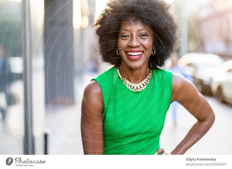 Portrait of a mature woman wearing green dress standing in the city people downtown businesswoman joy urban black natural attractive black woman happiness