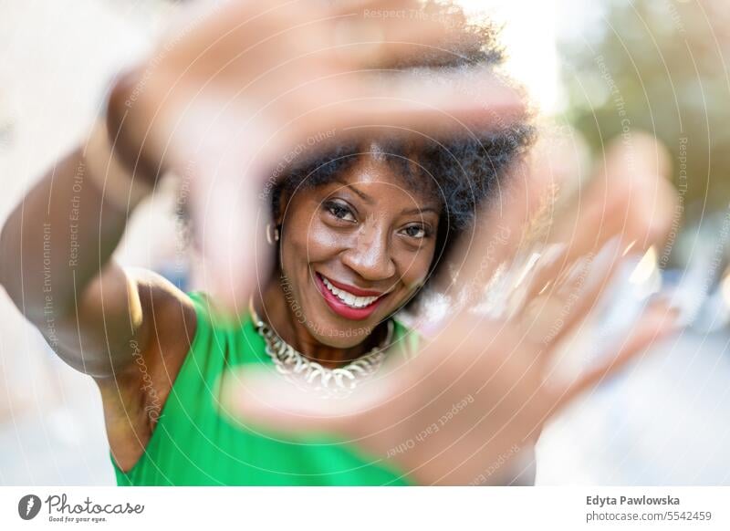 Portrait of a beautiful young woman gesturing outdoors people downtown businesswoman joy urban black natural attractive city black woman happiness street happy