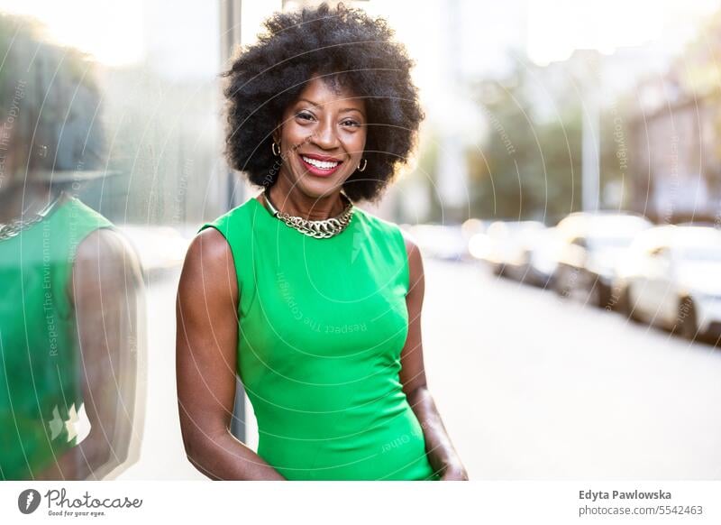 Portrait of a mature woman wearing green dress standing in the city people downtown businesswoman joy urban black natural attractive black woman happiness