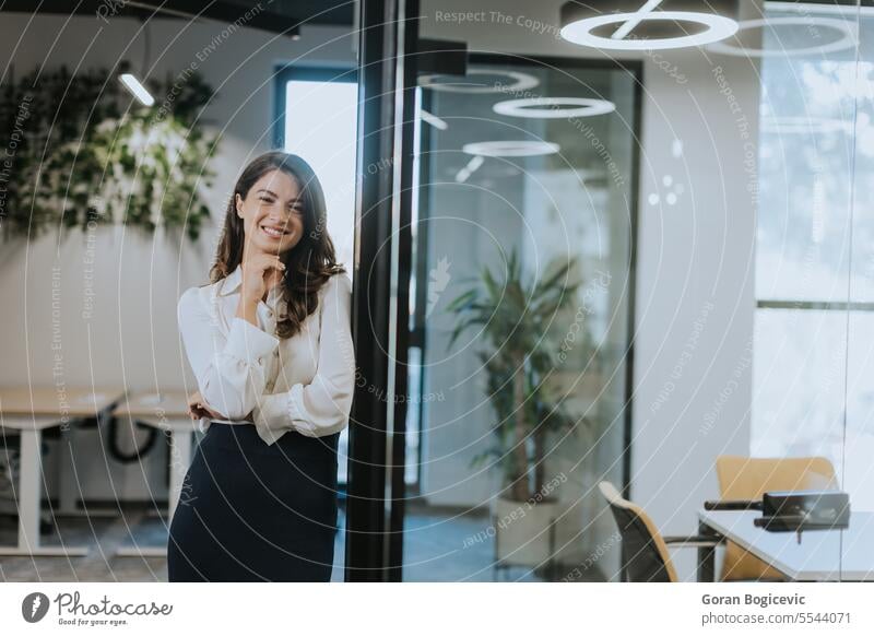 Young business woman standing with arms crossed in the modern office employee businesswoman manager portrait leader professional executive female smiling work