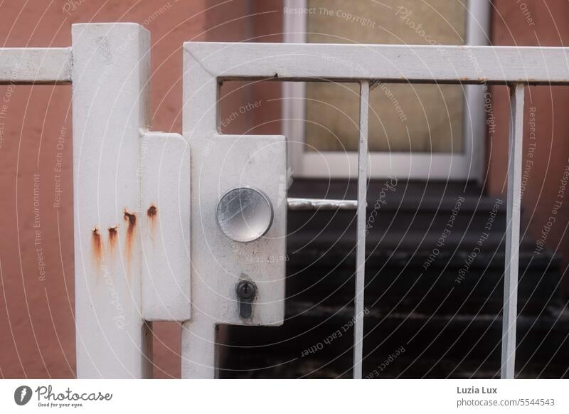 An old entrance gate with single rust stains, locked. shape Demanding Varnished Entrance White Detail Old door handle Old fashioned Style Stylish Close-up