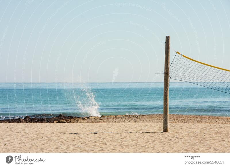 Beach volleyball court (post and net) on sandy beach with sea in background Volleyball beach volleyball Ocean ocean Net Playing field Pole Ball sport vacation