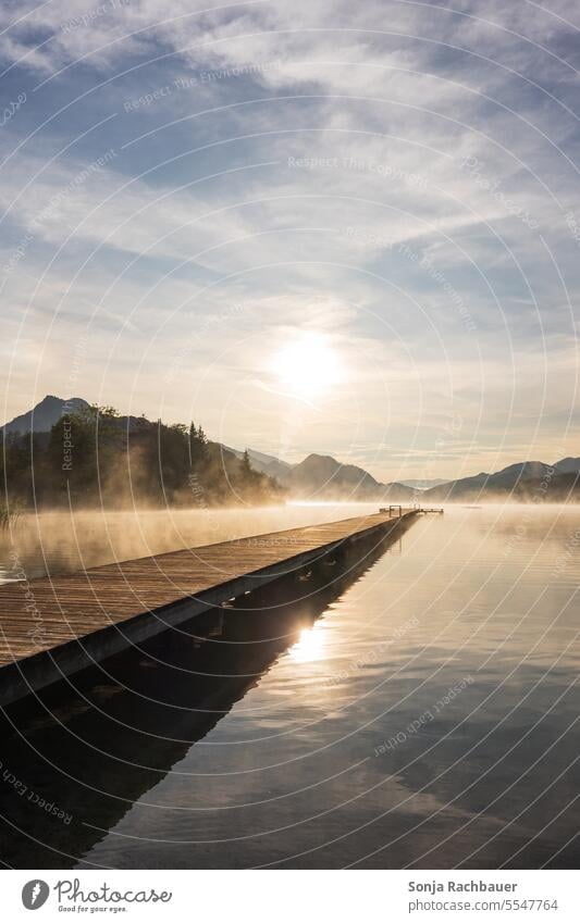 Sunrise at lake Fuschlsee in Austria Lake Fog Sky wooden walkway Reflection Water Idyll Lakeside Salzkammergut Footbridge Deserted Nature Calm Landscape