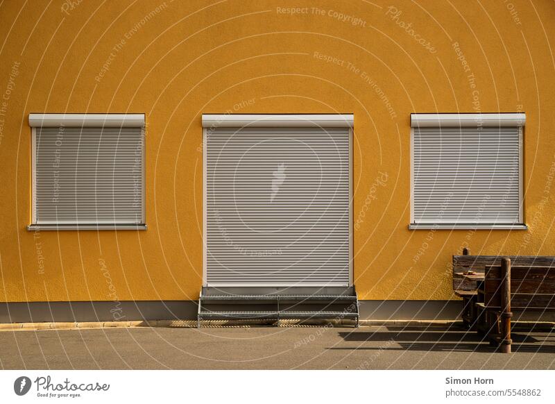 Building view with closed shutters and table with benches Roller shutter Frontal Closed Venetian blinds opaque Hidden covert Shielded Shadow Window Facade