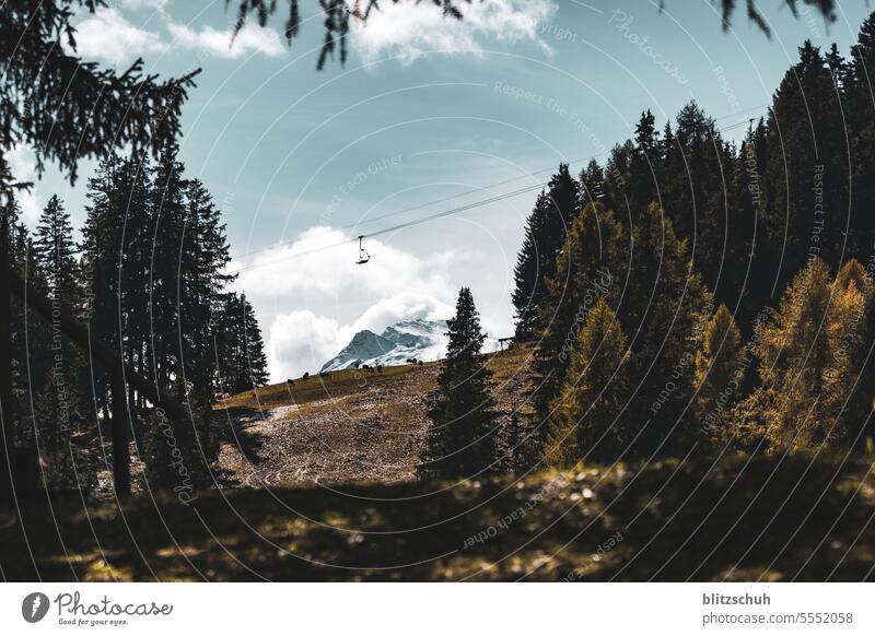 Lonely chairlift with snow covered mountain in background chair lift Mountain Nature Tourism Landscape Vacation & Travel Snow Alps Clouds Rock mountains Peak