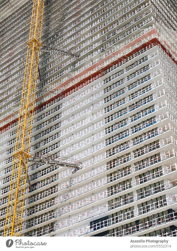 Modern unfinished skyscraper witha yellow lifting crane attached. apartment architectural architecture background balcony block building business cement city