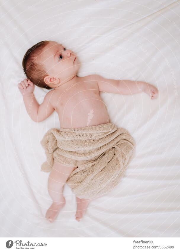 Portrait of a newborn in studio lighting against white baby firstborn portrait laying laying down copy space parenthood motherhood innocence life labor young