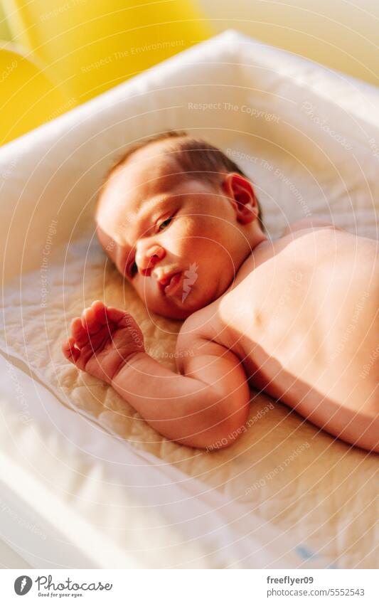 Portrait of a newborn on a baby changer portrait sunlight copy space parenthood motherhood innocence life labor young boy happy small pregnancy little childhood