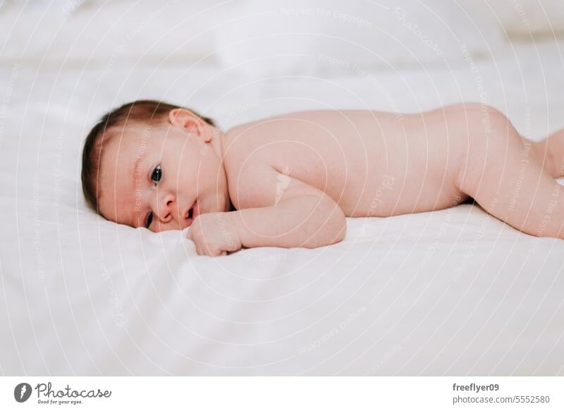 newborn in studio lighting against white baby firstborn portrait laying laying down copy space parenthood motherhood innocence life labor young boy happy small