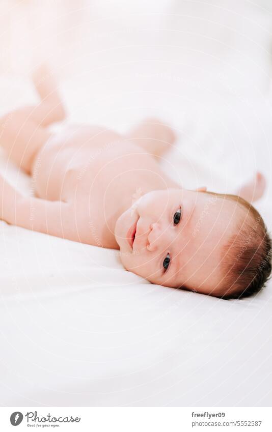 newborn in studio lighting against white baby firstborn portrait laying laying down copy space parenthood motherhood innocence life labor young boy happy small