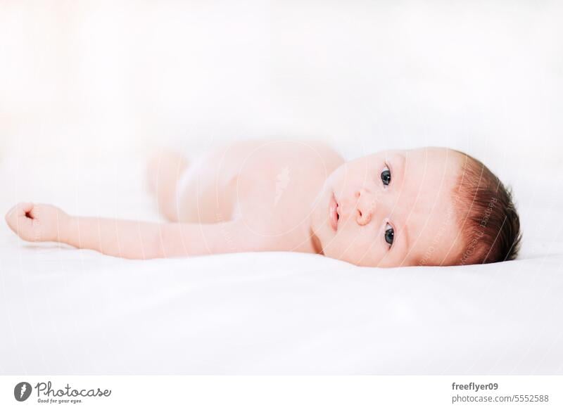 newborn in studio lighting against white baby firstborn portrait laying laying down copy space parenthood motherhood innocence life labor young boy happy small