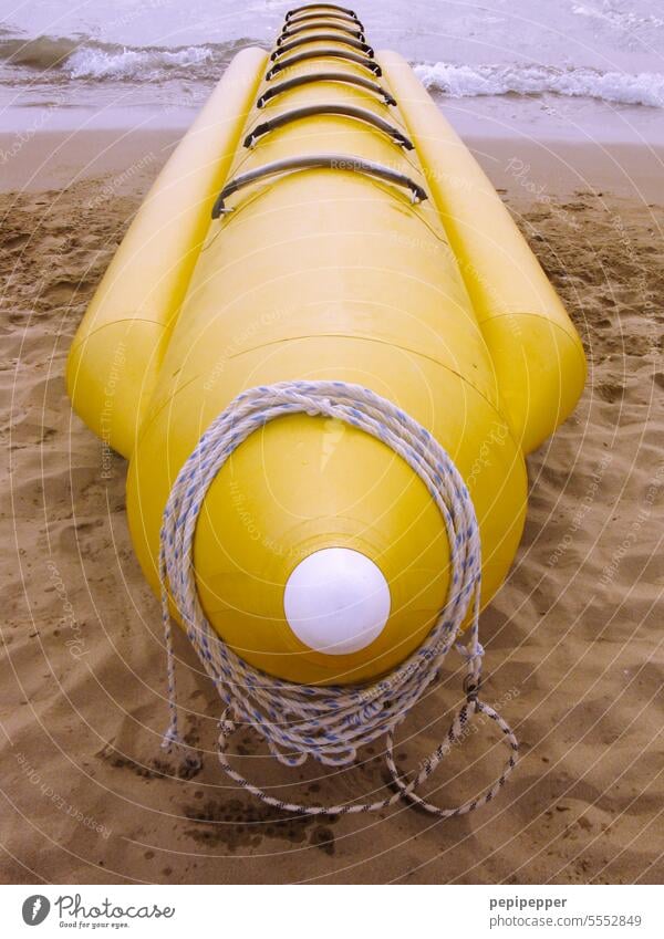 looks like a Yellow Submarine - yellow inflatable banana boat lying on beach Banana boat Fruit Boating trip Vacation & Travel Tourism Navigation Watercraft