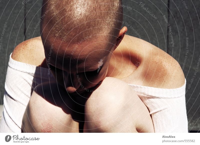 Young woman with very short hair and freckles sitting with her head on her knees Youth (Young adults) Knee Head Freckles Shoulder 18 - 30 years Adults Top