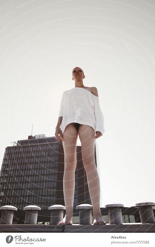 young, tall woman with very short hair stands on a chimney in front of a high-rise building Young woman Youth (Young adults) 18 - 30 years Adults Roof Chimney