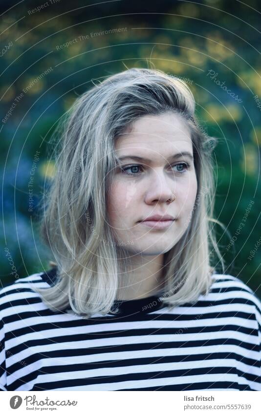 BEAUTIFUL YOUNG WOMAN SURROUNDED BY FLOWERS Woman youthful Blonde pretty Attractive naturally Striped looking away Nose ring naturalness flowers Lifestyle