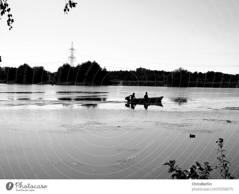 Black and white photo small boat with 2 people on a river Boating trip Navigation Water Vacation & Travel Exterior shot Tourism Watercraft Trip Adventure