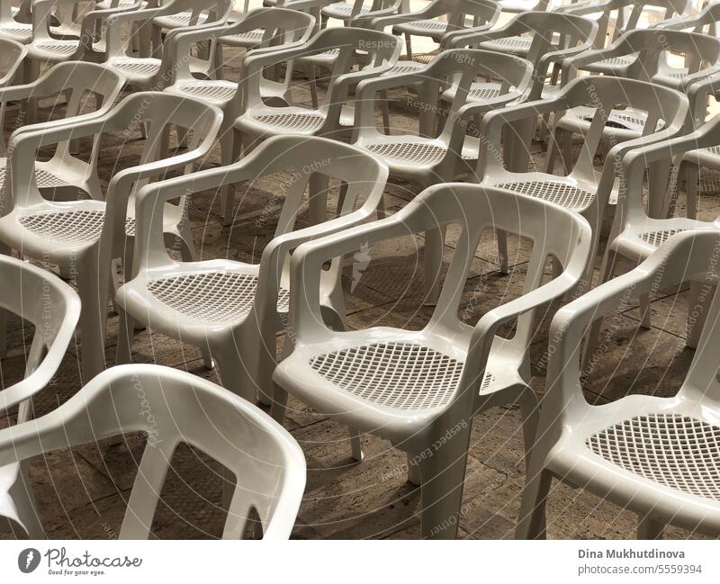 Empty rows of white plastic seats or chairs pattern at outdoor concert event or open air theater. No audience at movie theater outdoors. cinema Row of seats