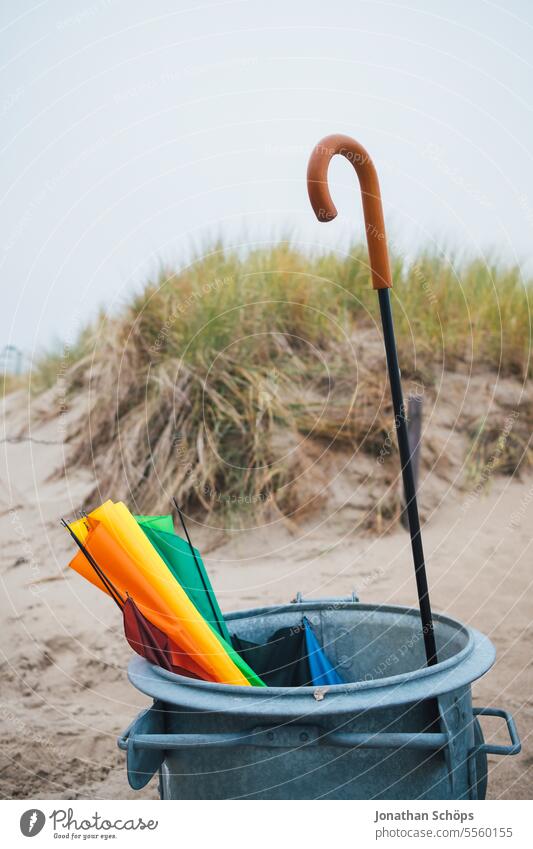 Colorful umbrella in a garbage can on the beach Autumn Ocean Off-Season Baltic Sea travel Beach vacation Warnemuende Winter Umbrella Umbrellas & Shades