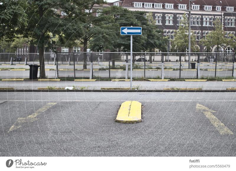 Lone one-way street sign in parking lot in front of fence One-way street Transport Parking lot Driving Signs and labeling Deserted Road traffic Road sign