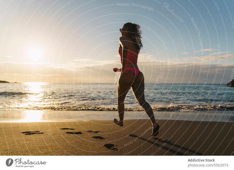 Happy woman running on sandy beach happy cheerful sea seaside barefoot summer carefree vacation bikini smile nature sun positive enjoy travel pleasure coast