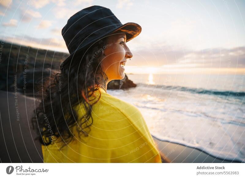 Cheerful woman looking away beach sea pensive seashore ocean thoughtful smile calm coast female sand wave nature cheerful wind water happy Tenerife