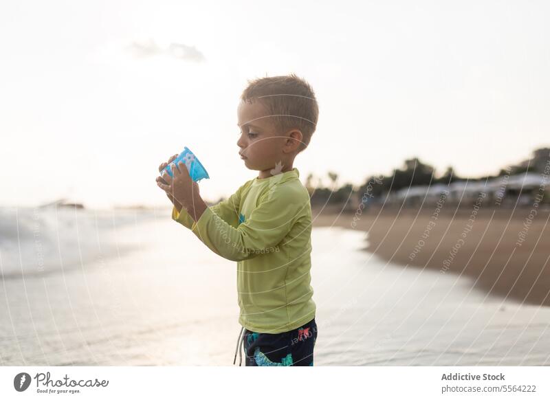 Child playing on sandy beach in summer day child toy shore waves sunny kid preschool childhood little coast nature travel seafront boy trip weekend adventure