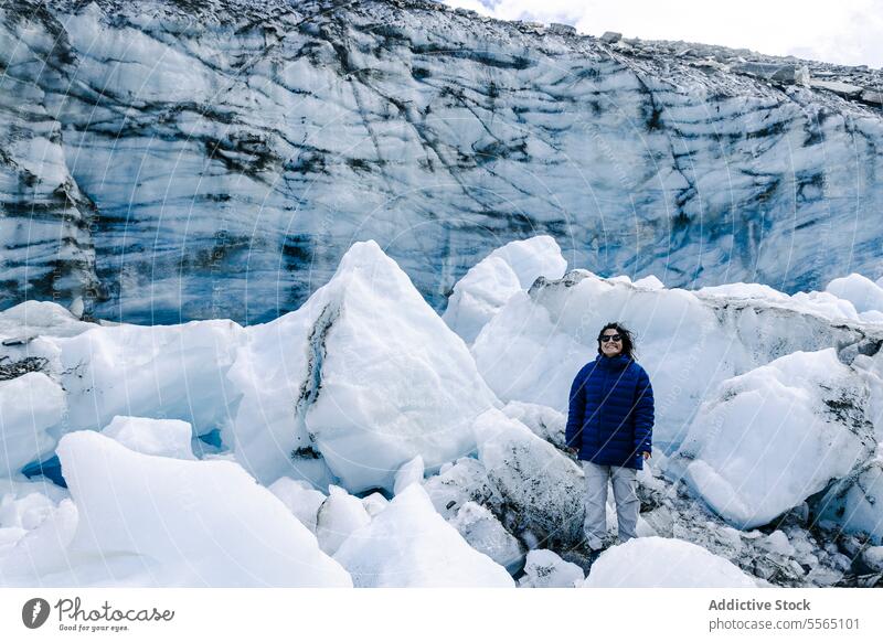 Glacier explorer amidst ice formations glacier blue jacket pattern backdrop nature landscape winter cold mountain adventure outdoor scenic beauty environment