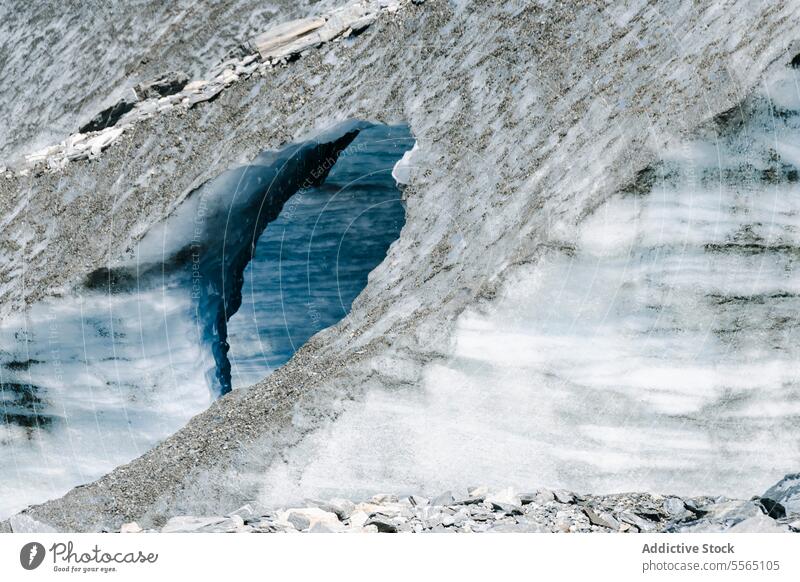 Arched glacier in rocky landscape arch terrain sky cloudy expansive nature ice blue white mountain environment beauty formation winter erosion outdoor cold