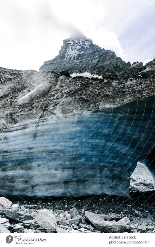 Arched glacier in rocky landscape arch terrain sky cloudy expansive nature ice blue white mountain environment beauty formation winter erosion outdoor cold