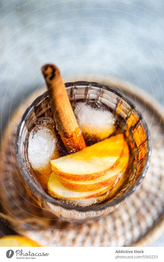 Apple cider cocktail garnish apple cinnamon stick anise star slice crystal glass cube texture background drink beverage alcohol refreshment autumn seasonal