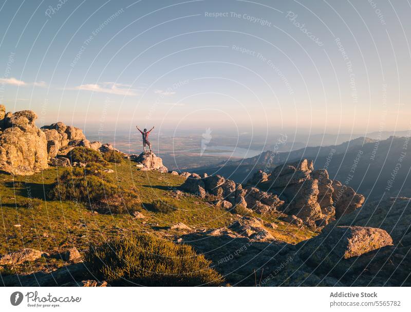 Anonymous climber admiring view from mountain top landscape adventure travel equipment backpack hobby stone rock scenic hiking trekking altitude sunny daytime