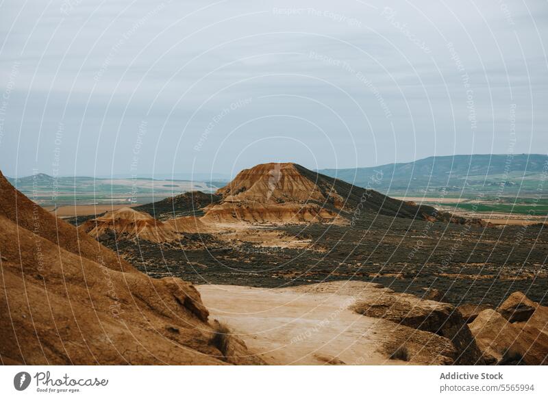 A large rock formation in the middle of a desert bardenas reales navarra arid dry sand dunes landscape geology erosion mountain stone nature wilderness barren